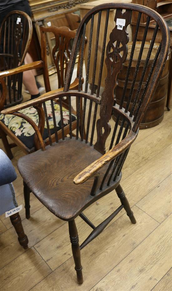 An early 19th century elm and ash wheelback elbow chair